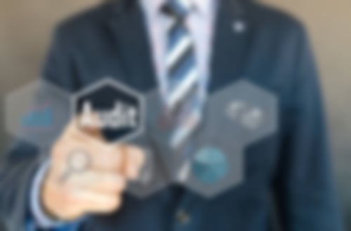Im Vordergrund ist eine virtuelle Auswahl in Kachelform. Ein Mann im Anzug im Hintergrund drückt auf die Kachel mit der Aufschrift Audit