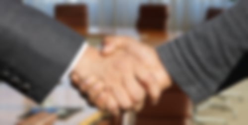 Zwei Männer im Anzug schütteln sich die Hand, es sind nur die Hände zu sehen
