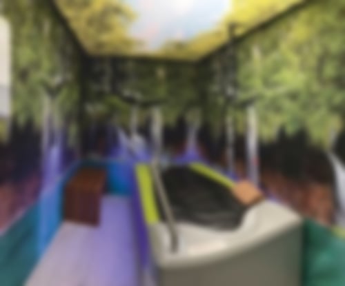 Die Medistream Massageliege im MediVital Therapiezentrum. Die Wände in dem kleinen Raum stellen einen Wasserfall dar