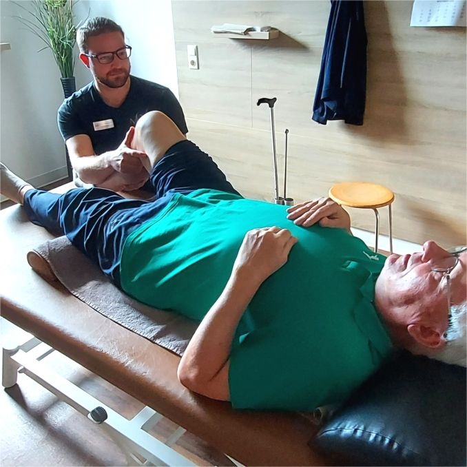 Ein Physiotherapeut des MediVital Therapiezentrums behandelt das Bein eines Patienten auf einer Liege