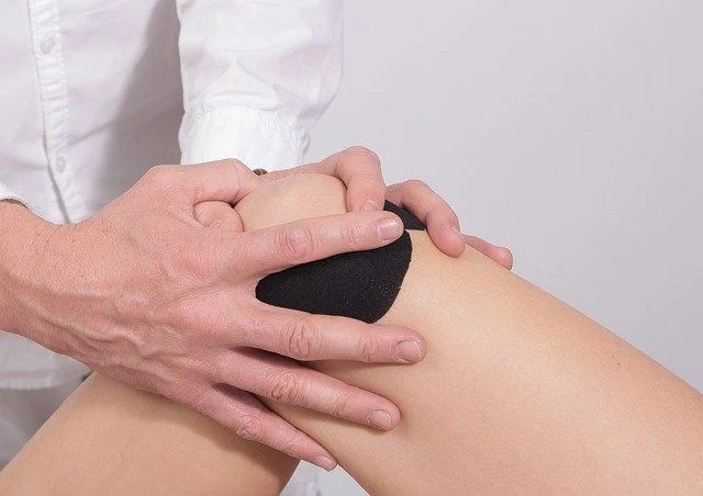 Ein Knie wird behandelt mit einem Kinesio Tape