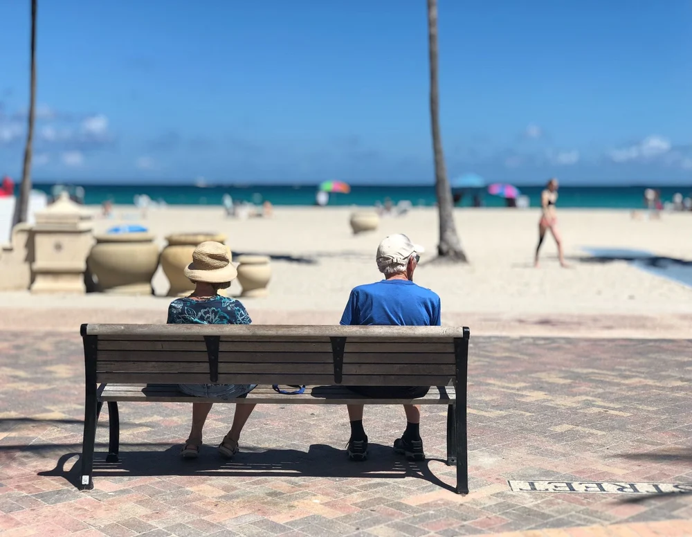 Rentnerpaar auf einer Bank am Strand