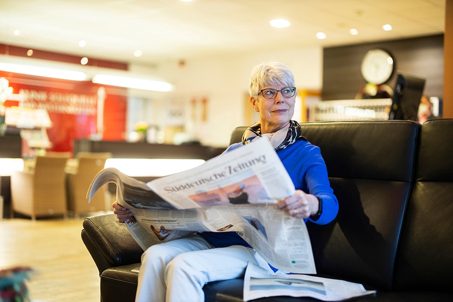 Frau liest Zeitung im Foyer der Klinik Solequelle