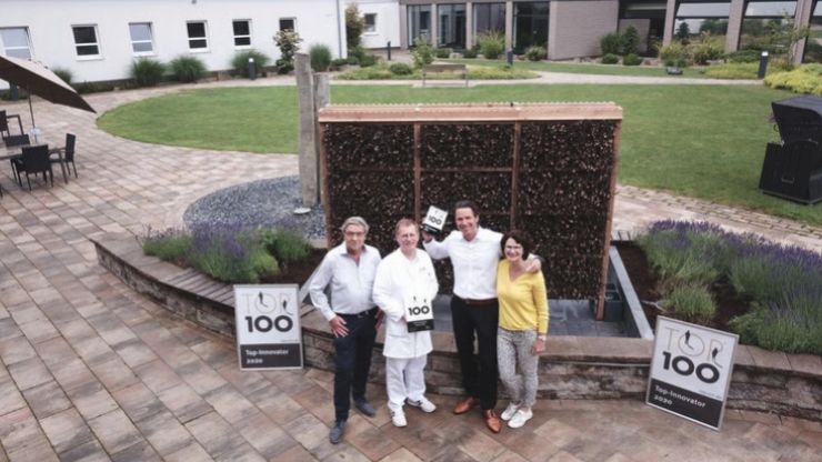Die Geschäftsführung Familie Kemper und Uwe Rückert präsentieren das TOP100 Siegel vor unserer Saline im Garten der Klinik Solequelle