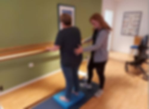 Eine Frau und eine Ergotherapeutin am Barren