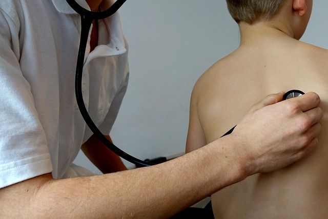Ein Arzt hört die Lunge einen Patienten ab mit einem Stethoskop