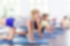 mehrere Trainierende in einer Gruppe bei einer Gymnastikübung