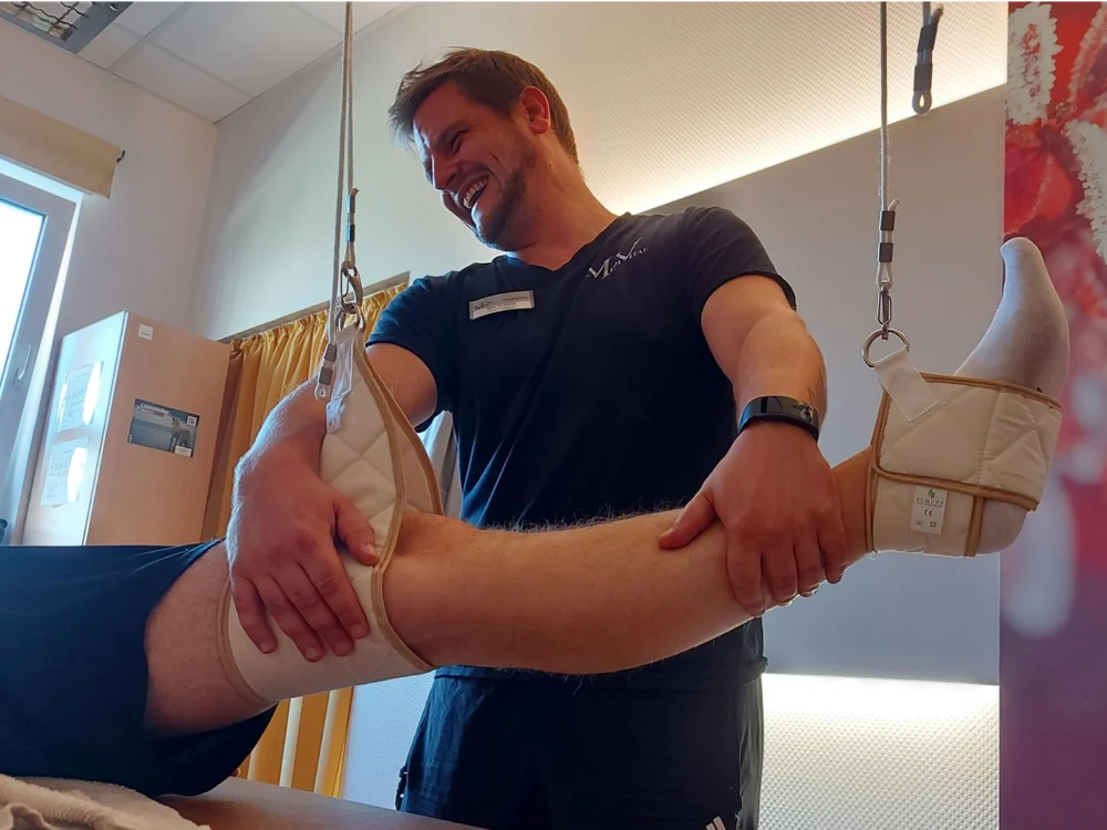 Ein Therapeut behandelt das Bein eines Patienten