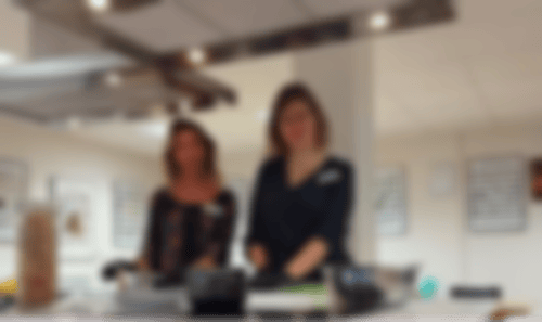 2 Ernährungsberaterinnen der Klinik Solequelle stehen in einer Lehrküche am Herd und schauen in die Kamera