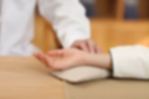 Pulskontrolle an einer ausgestreckten Hand