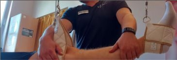 Ein Therapeut behandelt das Bein eines Patienten