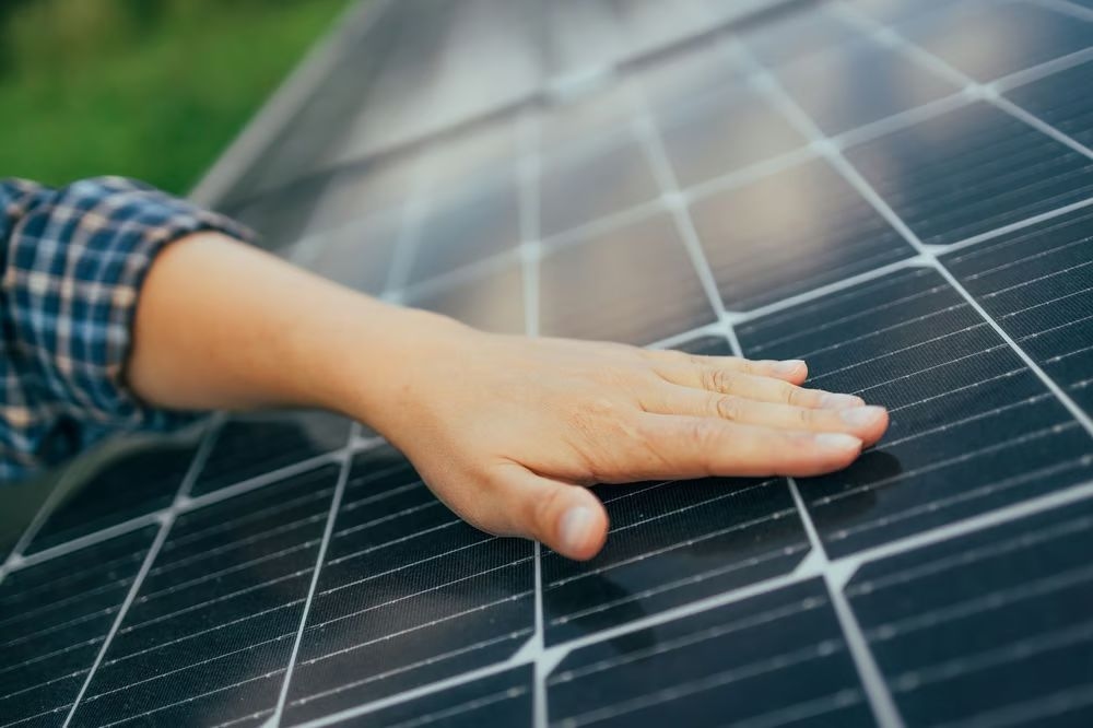 Foto: PV-Module mit Hand darüber