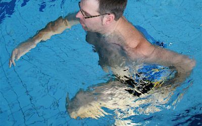 Mann im Wasser beim Aquajogging mit Gürtel