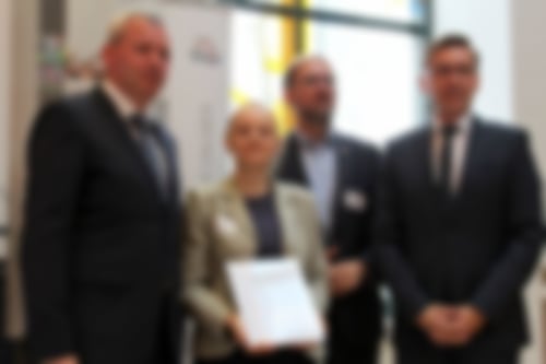 Das Bild zeigt vier Personen bei der Q-Auszeichnung. Herr Hövelmann, Frau Rieder (für unseren Verband, Herr Zimmer und Herr Wünsch.