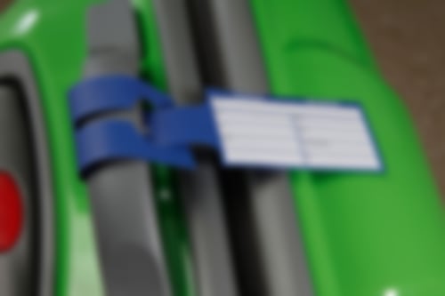 Grüner Koffer mit einem Kofferanhänger