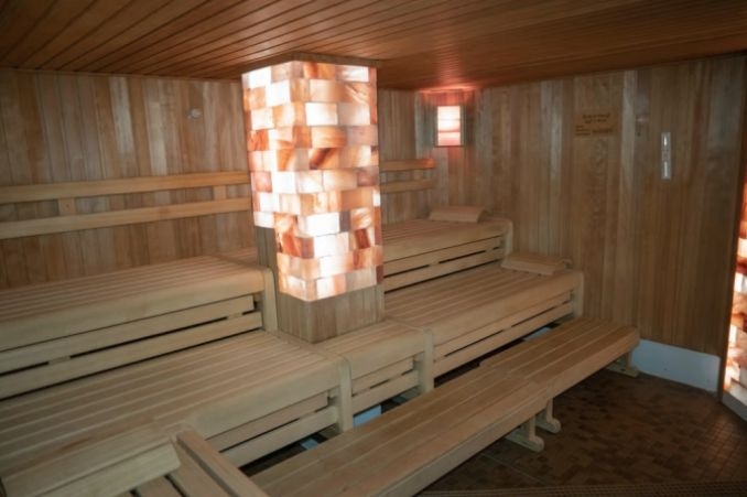 Innenansicht unserer Westernkötter Salzstein-Sauna. Inmitten der hölzernen Bänke steht eine Salzsteinsäule.