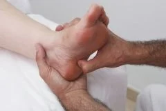 Zu sehen ist ein Fuß und zwei Hände, die den Fuß massieren.