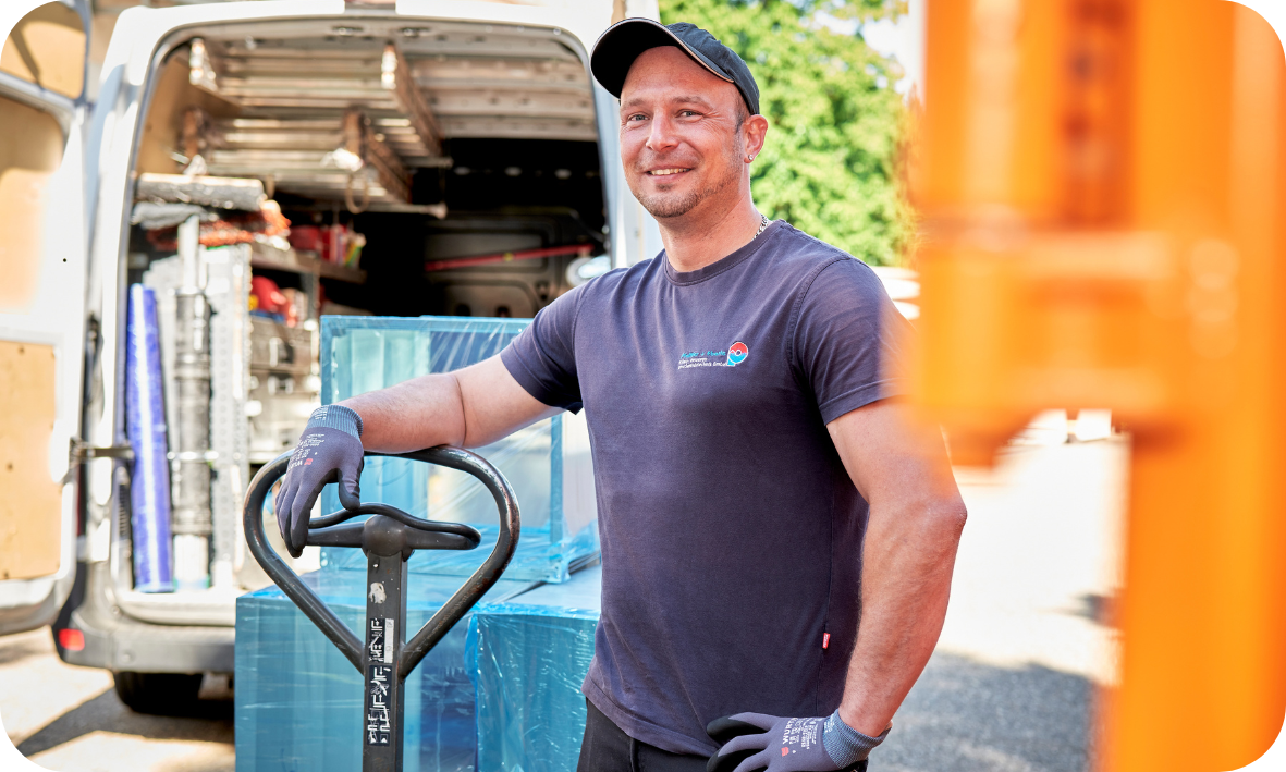 Ein Mitarbeiter verlädt mit einem Hubwagen ein Kundendienstfahrzeug