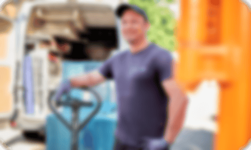 Ein Mitarbeiter verlädt mit einem Hubwagen ein Kundendienstfahrzeug