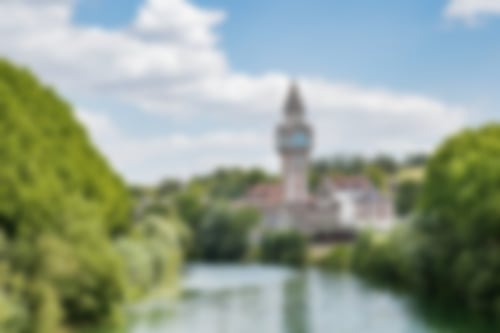 Fluß mit grüner Böschung, im Mittelpunkt eine große Kirche am Flussufer