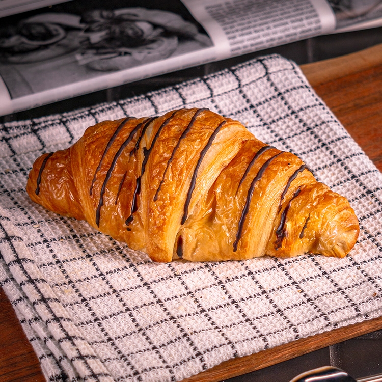 Knuspriges Schokocroissant mit zarter Butternote, gefüllt und verziert mit feiner Schokocreme bei Essmann’s Backstube