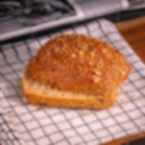 Herzhaftes Dinkelvollkornbrötchen mit goldbrauner Kruste, bestreut mit Dinkelflocken und Sonnenblumenkernen bei Essmann’s Backstube