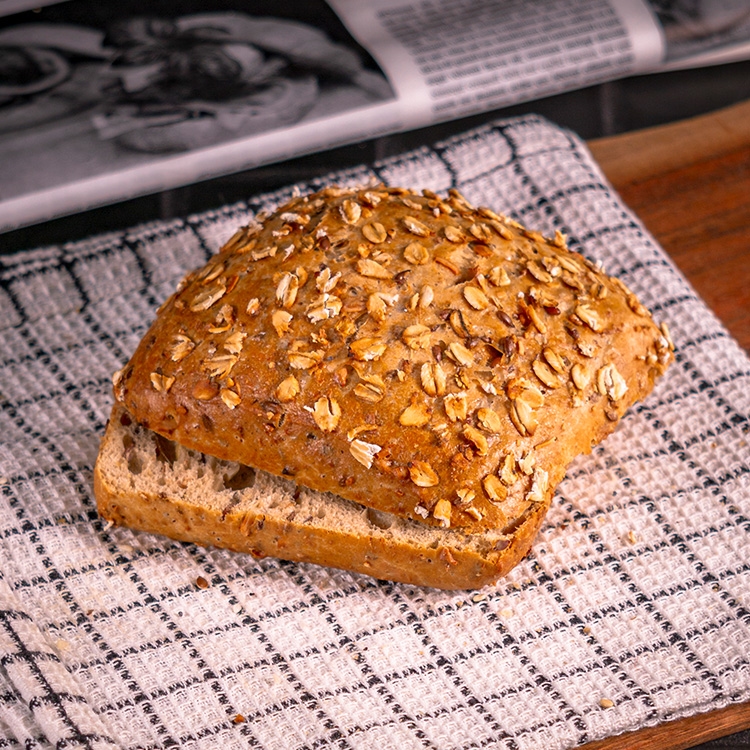 Saftiges Mehrkornbrötchen mit goldbrauner Kruste, getoppt mit kernigen Haferflocken, gebacken bei Essmann’s Backstube