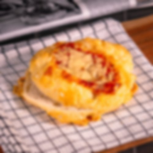 Weiches Weizenbrötchen mit pikanter Chilisauce und würziger Käsekruste überbacken bei Essmann’s Backstube