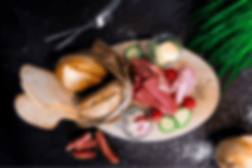 Kräftiges Frühstück mit Brötchen, Brot, Butter, Mett, Salami, Serrano und Kochschinken bei Essmann’s Backstube