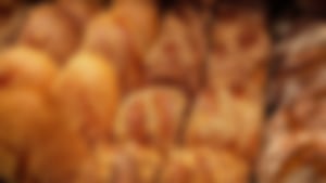 Verschiedene frisch gebackene Brotsorten mit knuspriger Kruste und Körnern, dicht aneinandergereiht in einer Auslage.