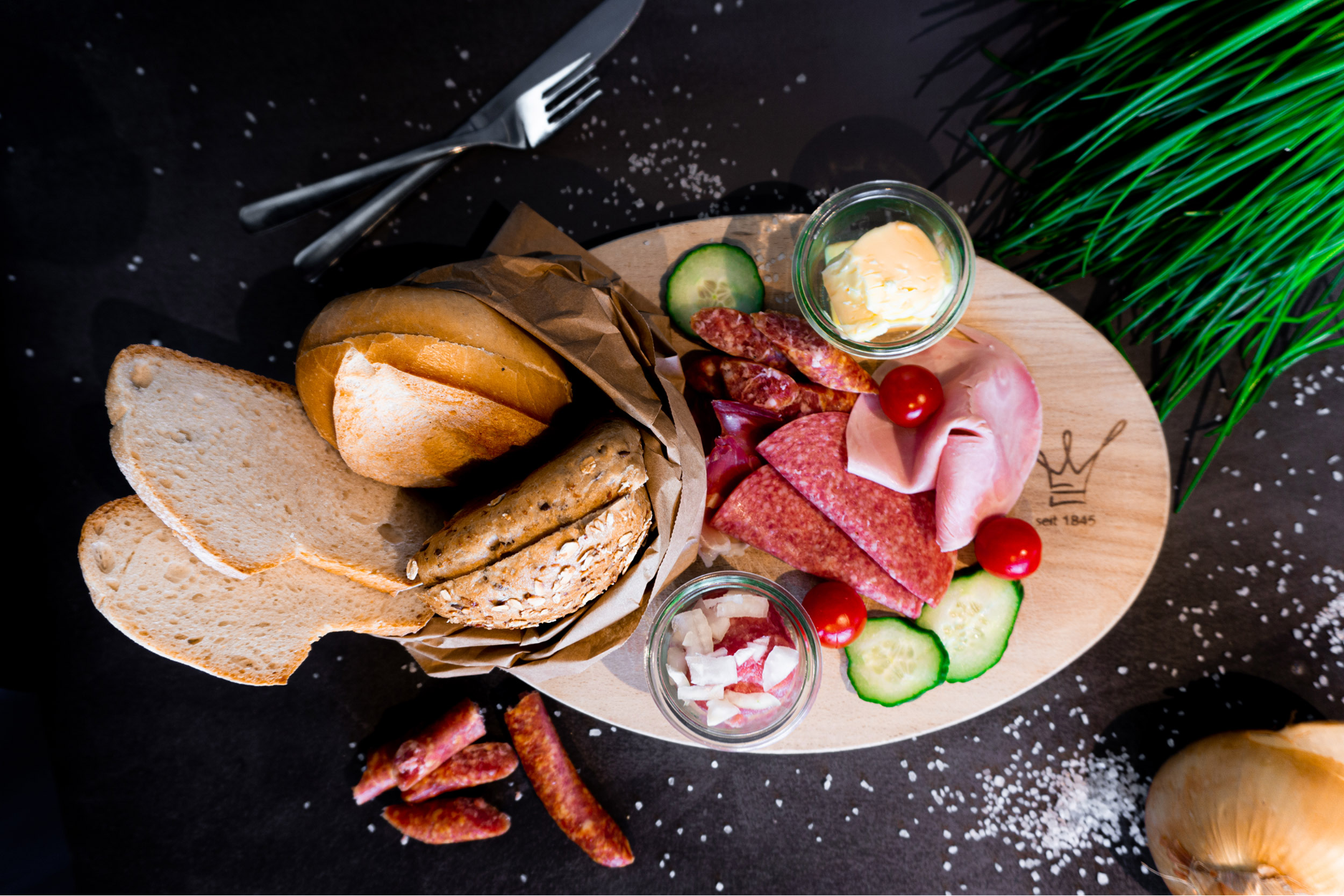Großes Frühstück mit frischen Brötchen, Brot und verschiedenen Schinken von der Bäckerei Essmanns Backstube.