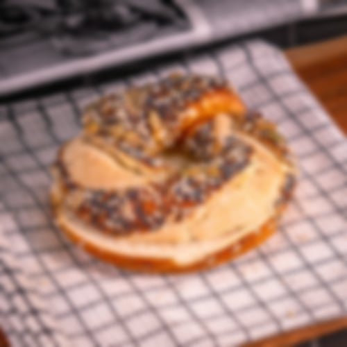 Goldbrauner Laugenring mit dekorativer Körnermischung aus Mohn, Sesam und Kürbiskernen bei Essmann’s Backstube