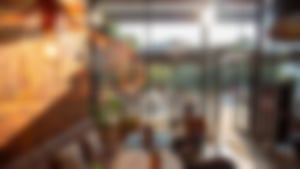 Modern eingerichtetes Café von Essmann’s Backstube mit gemütlichen Sitzplätzen, warmem Licht und sonnigem Außenbereich mit Schirmen.