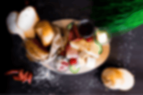 Herzhaftes Frühstück mit Brötchen, Brotscheiben, Butter, Konfitüre, Käse, Mett, Serrano und Putenbrust bei Essmann’s Backstube