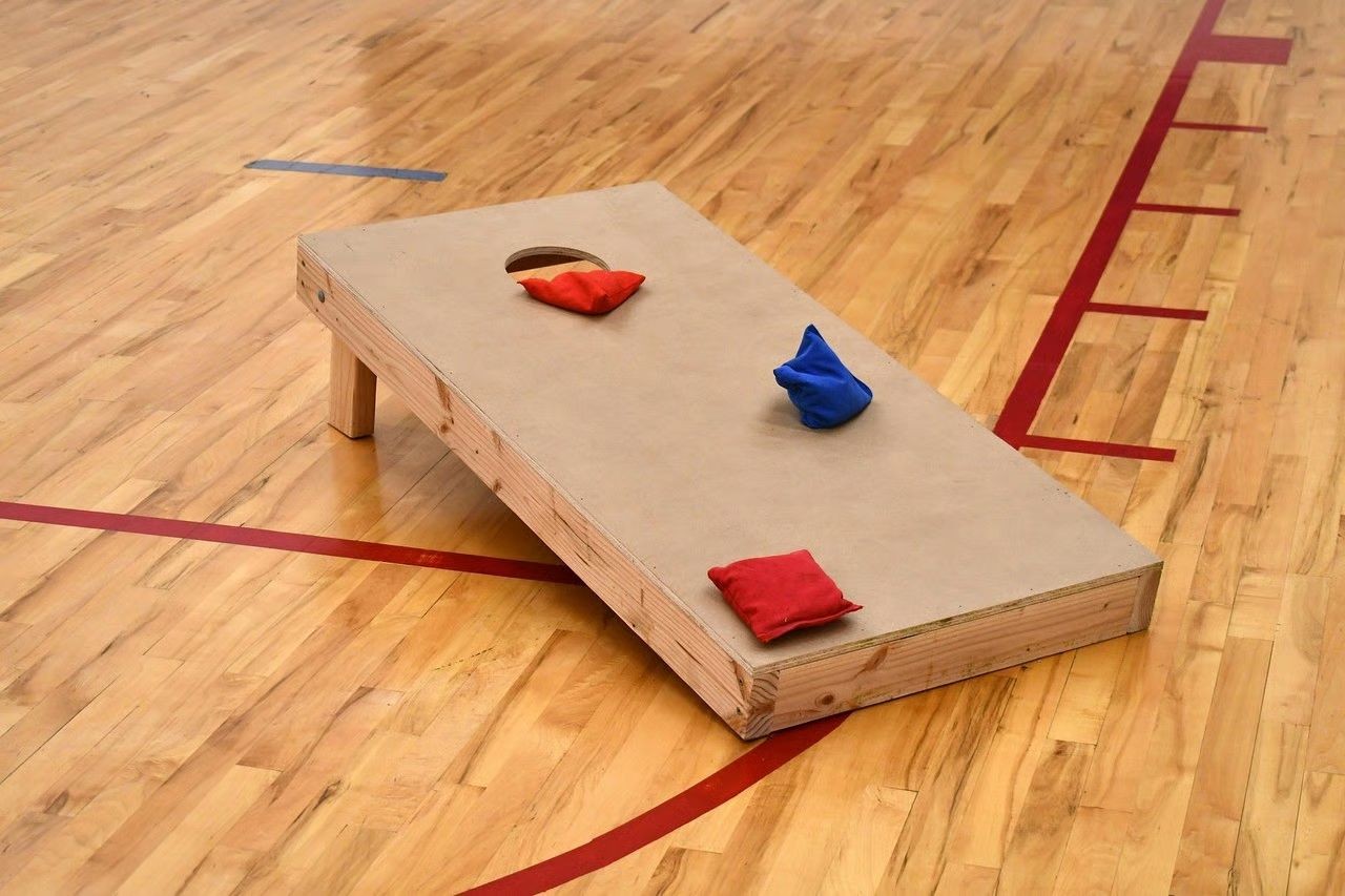 Cornehole, ein texanisches Freizeit- und Präzisions-Wurfspiel, bei dem gefüllte Säcke auf ein angehobenes Holzbrett mit einem Loch geworfen werden.