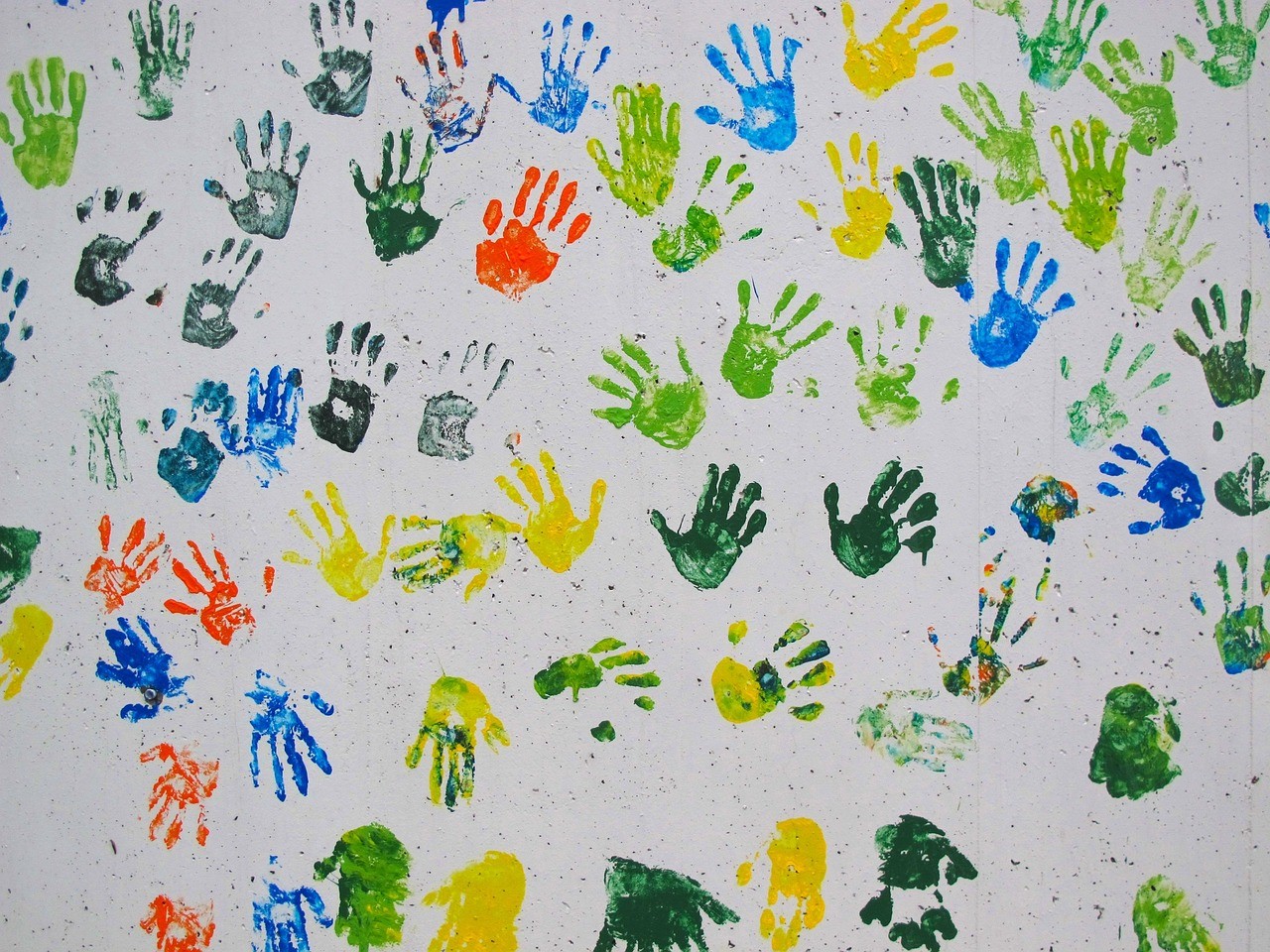 Bunte Handabdrücke von Kindern an einer Wand