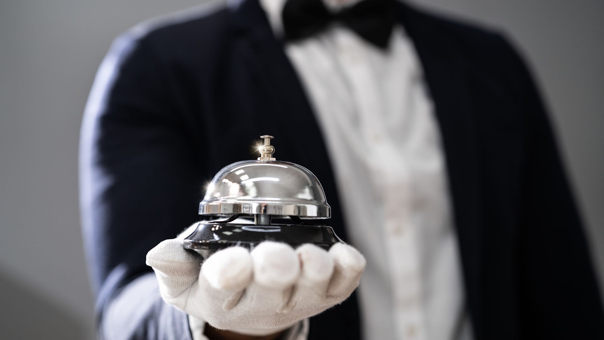 Ein Concierge hält eine Glocke